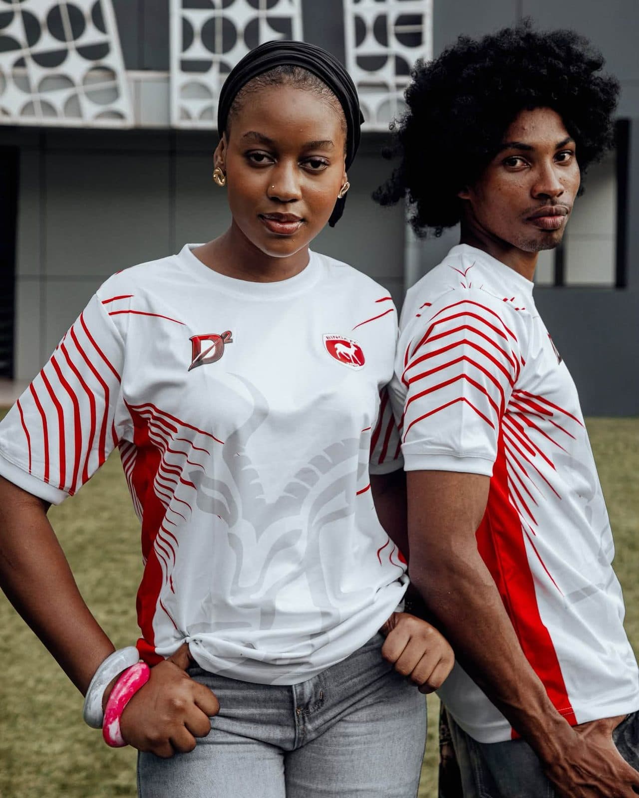 Deux joueurs en maillots blancs BINGA FC sur un terrain